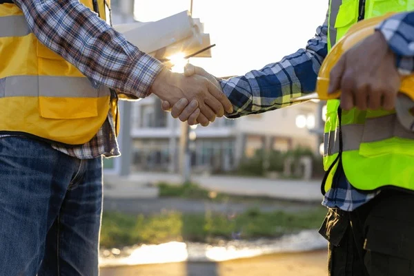 construction-workers-shaking-hands-site-600nw-2734196041